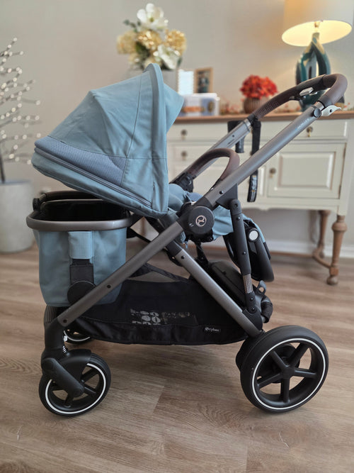 CYBEX eGazelle S with the stroller seat reclined fully flat and the shopping basket still mounted in the lower slot underneath