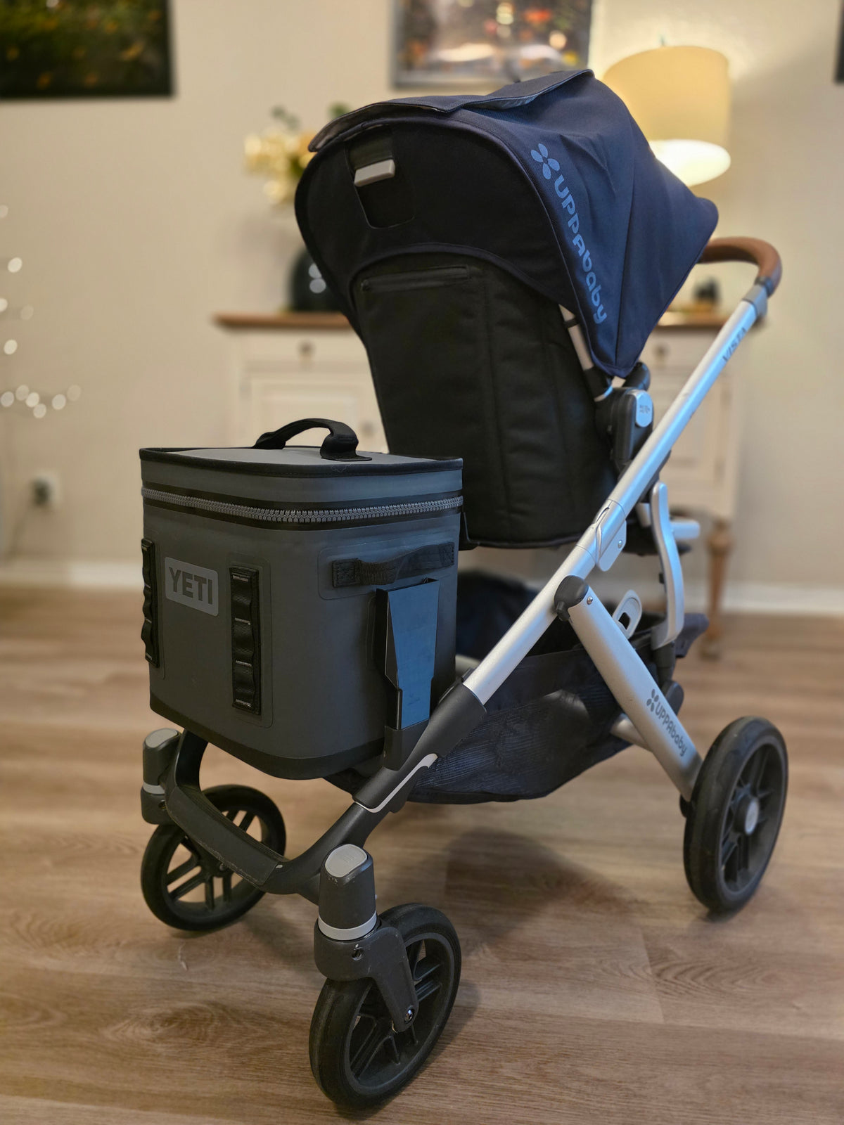 Charcoal YETI Hopper Flip mounted low on the side of an UPPAbaby Vista, with the stroller's own storage basket still free underneath