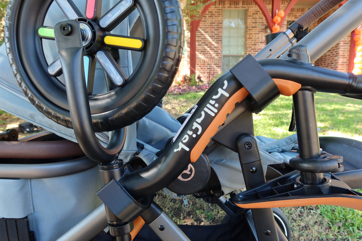 Close-up of the balance bike's frame resting in the two black holders clipped to the CYBEX eGazelle S frame tube, held by its own weight with no strap.
