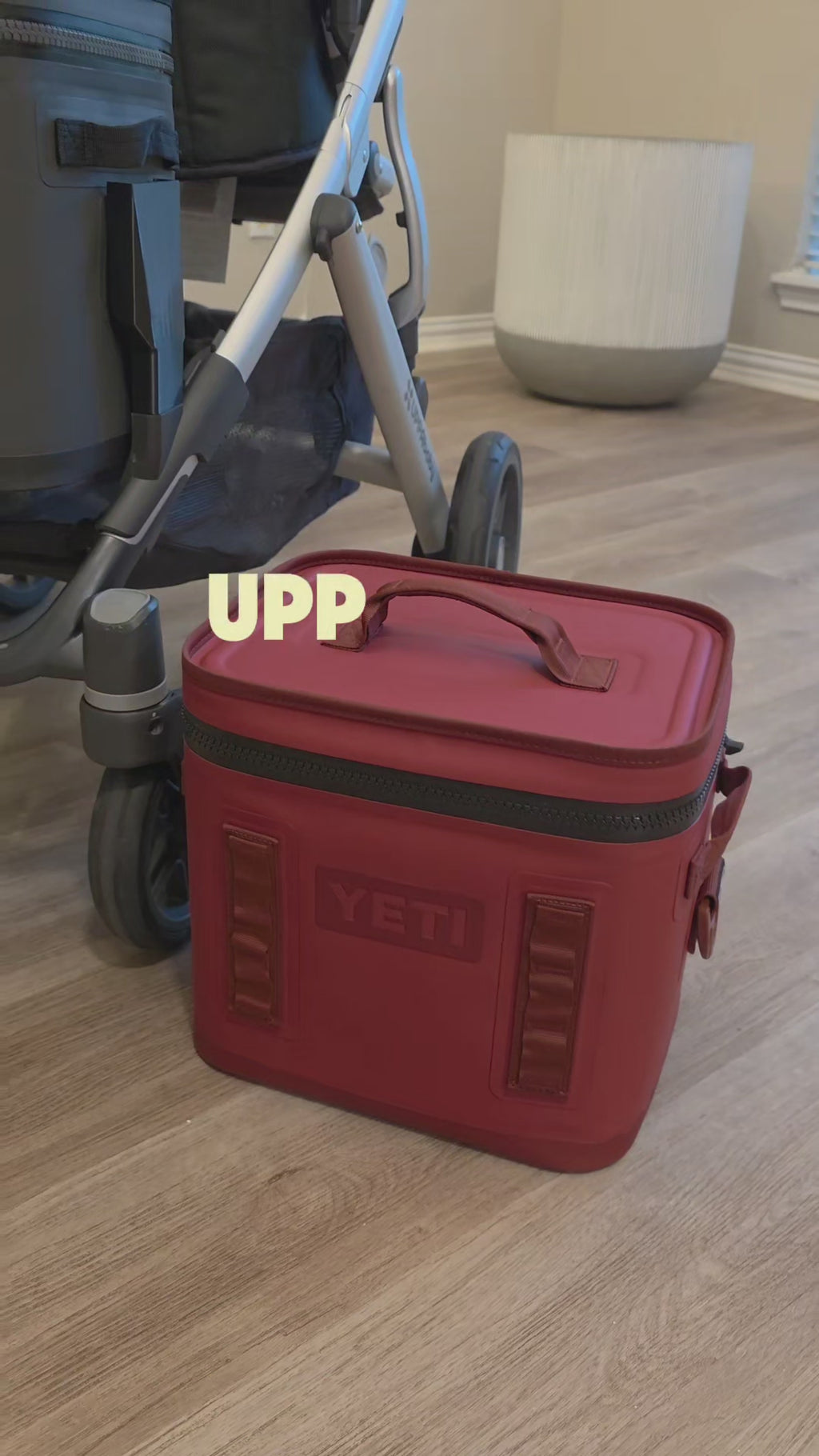 A YETI Hopper Flip soft cooler carried in the lower position of an UPPAbaby Vista frame, shown from the side and the rear with the stroller basket below it.