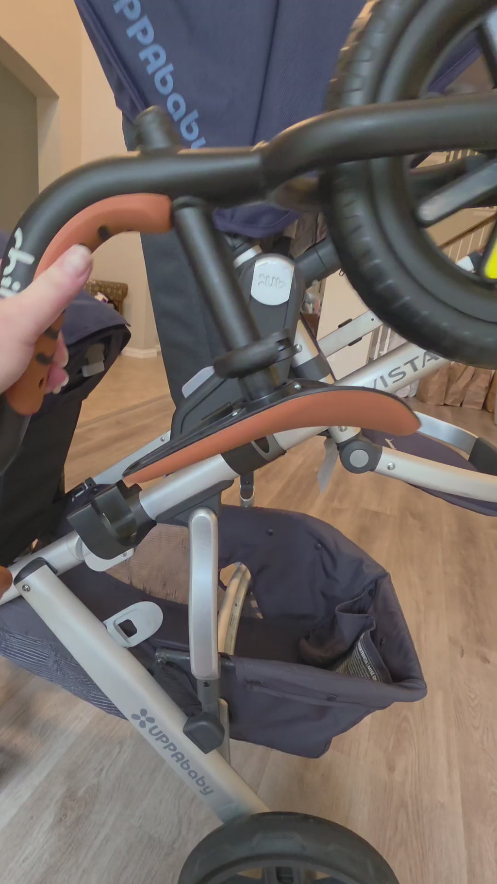 Walking around an UPPAbaby Vista with a balance bike loaded on the Stroller House holders, showing how it sits on the frame and clears the wheels.